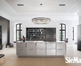 SieMatic 2002 BAL SQ lak graphite glanzend keukeneiland: front aluminium geborsteld met omlijsting  in metaal in facet verchroomd, SieMatic werkblad in edelstaal mat geborsteld.